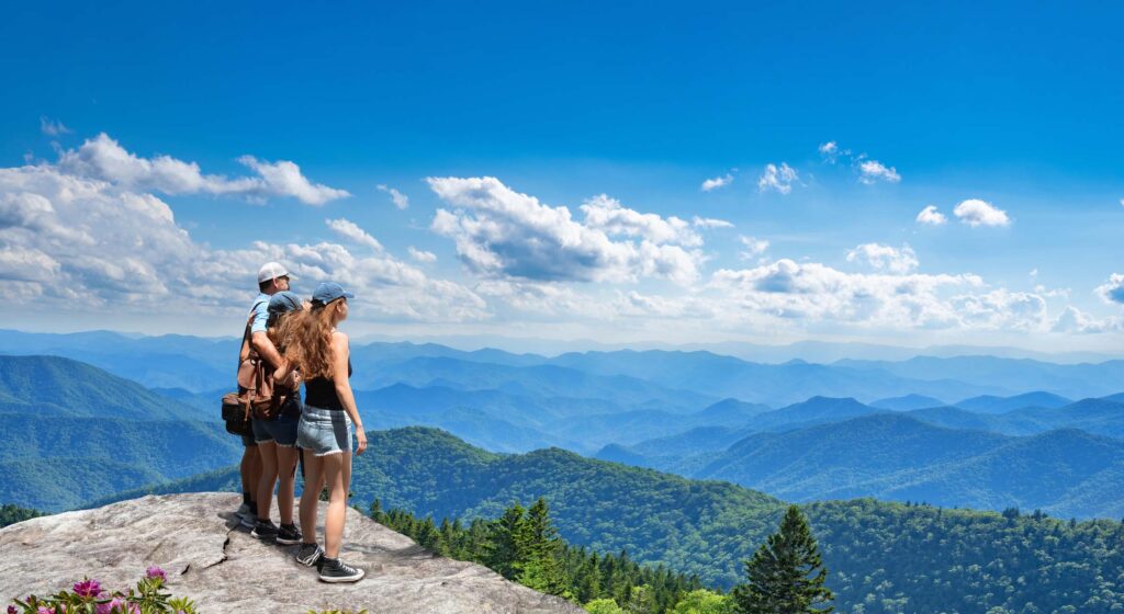 Famille debout au sommet de la montagne, regardant le magnifique paysage de montagne de l'été. Personnes en randonnée en vacances, profitant d'une vue magnifique. Les Great Smoky Mountains en arrière-plan. Près d'Asheaville, Caroline du Nord, États-Unis.